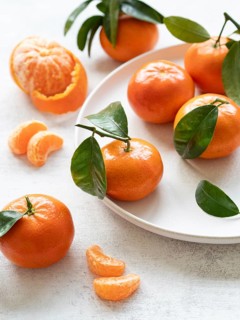 Vibrant tangerines with green leaves, showcasing freshness and citrusy appeal, perfect for healthy