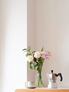 Enjoying a quiet moment with coffee and flowers, creating a cozy and relaxing atmosphere in a