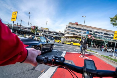 Riding a bike in a bike lane, marked in red to attract the attention of motorists, between 2 lanes,