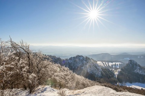 View over the hills and valleys from the mountain with hoarfrost on the branches in winter, Vápec,