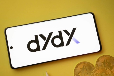Dhaka, Bangladesh- 03 Oct 2025:Dydx logo on smartphone screen near Bitcoin coin and QR code on
