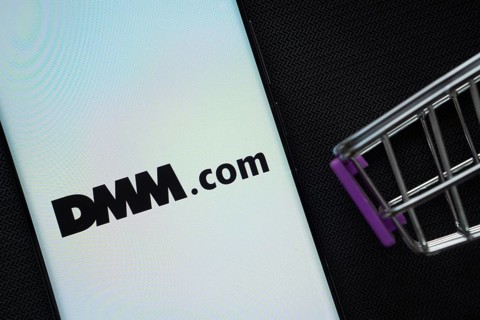 Dhaka, Bangladesh- 03 Oct 2025: A smartphone displaying the Dmm.com logo next to a miniature