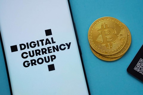 Dhaka, Bangladesh- 03 Oct 2025: Digital currency group logo on smartphone screen near Bitcoin coin