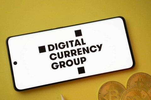 Dhaka, Bangladesh- 03 Oct 2025: Digital currency group logo on smartphone screen near Bitcoin coin