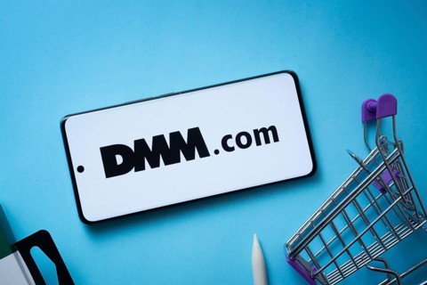 Dhaka, Bangladesh- 03 Oct 2025: Smartphone displaying Dmm.com logo with shopping cart on a blue