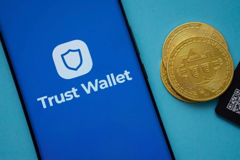 Dhaka, Bangladesh- 30 Sep 2025: Trust Wallet logo on smartphone screen near Bitcoin coin and QR