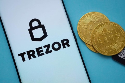 Dhaka, Bangladesh- 30 Sep 2025: Trezor logo on smartphone screen near Bitcoin coin and QR code on