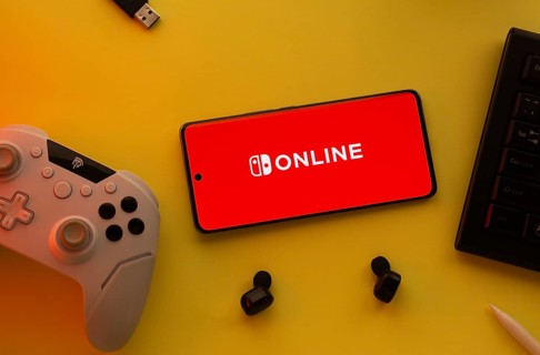 Dhaka, Bangladesh- 15 July 2025: Smartphone with nintendo online logo, game controller, and earbuds