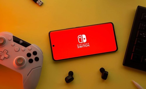 Dhaka, Bangladesh- 15 July 2025: Smartphone with nintendo switch logo, game controller, and earbuds