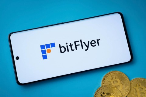 Dhaka, Bangladesh- 02 June 2025: Bitflyer logo on smartphone screen near Bitcoin coin and QR code