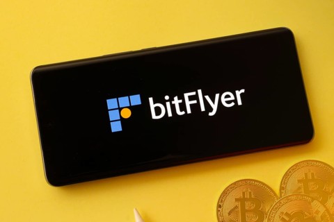 Dhaka, Bangladesh- 02 June 2025: Bitflyer logo on smartphone screen near Bitcoin coin and QR code