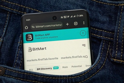 Dhaka, Bangladesh- 15 June 2025: A smartphone displaying the BitMart.com web interface peeks out of