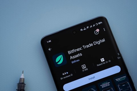 Dhaka, Bangladesh- 29 May 2025: On a blue surface, a smartphone displays the Bitfinex app within