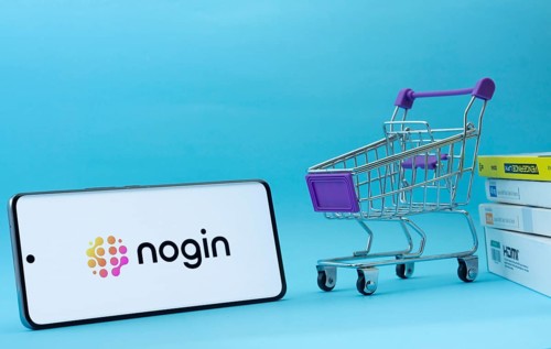 Dhaka, Bangladesh- 03 July 2025: Smartphone with nogin logo next to a small shopping cart and boxes