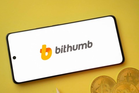Dhaka, Bangladesh- 07 May 2025: Bithumb logo on smartphone screen near Bitcoin coin and QR code on