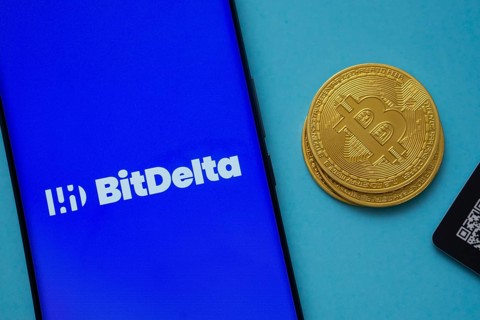 Dhaka, Bangladesh- 07 May 2025: BitDelta logo on smartphone screen near Bitcoin coin and QR code on