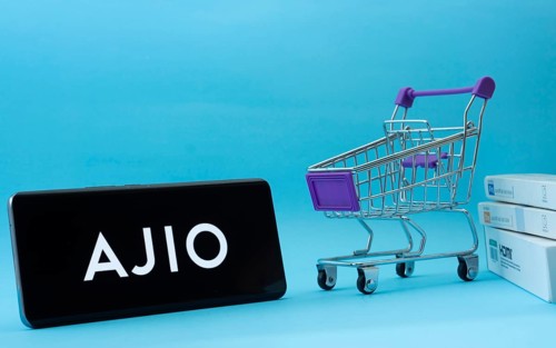 Dhaka, Bangladesh- 03 July 2025: Smartphone with AJIO logo next to a small shopping cart and boxes
