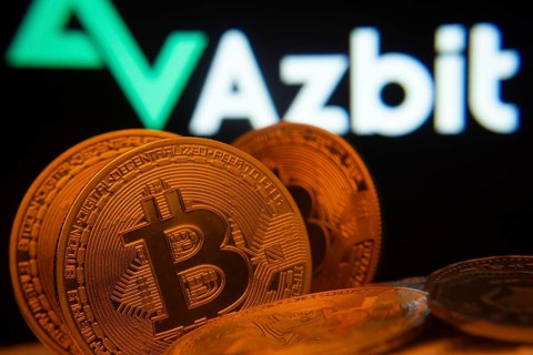 Dhaka, Bangladesh- 02 June 2025: Close-up of Bitcoin coins with the Azbit logo visible on a screen