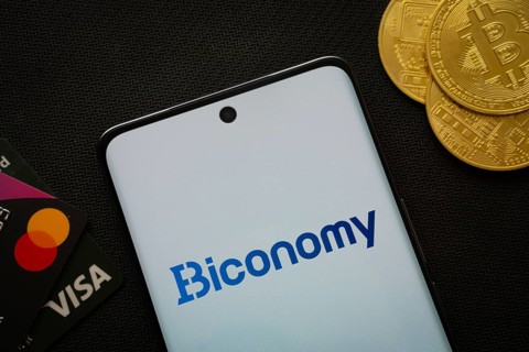 Dhaka, Bangladesh- 02 June 2025: Smartphone displaying Biconomy logo surrounded by Bitcoin coins