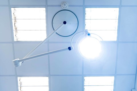 Bright operating or treatment room, view of medical examination light and ceiling lighting from the