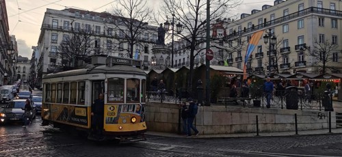Historic tram on a busy city street surrounded by classic buildings, Lisbon, Portugal