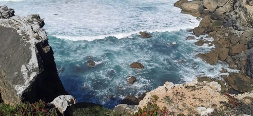 Turquoise waves crashing against rough cliffs by the sea, hiking the Fisherman's Trail, fishing