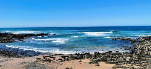 Hiking the fishing trail, Rota Vicentina, Clear blue sky with waves in blue water hitting rocky