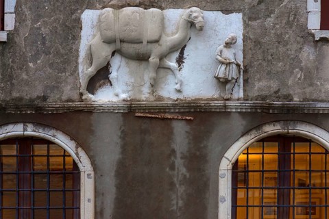 Historical relief with Moorish merchant and camel on the façade of a palazzo, Venice, Veneto, Italy