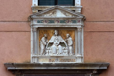 Sculpture of the Madonna of the Virgin Mary holding the faithful under her spread cloak, Madonna