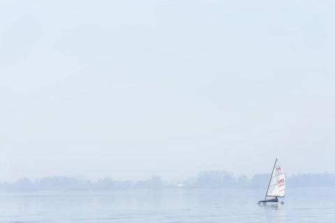 Ice sailor on frozen Dümmer Lake, on a fog-covered lake, quiet and peaceful winter landscape,