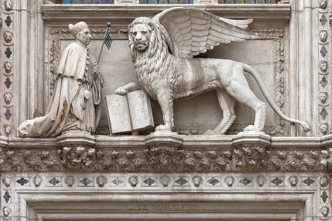 Doge kneels in front of St. Mark's Lion above the Porta della Carta of the Doge's Palace, Venice,