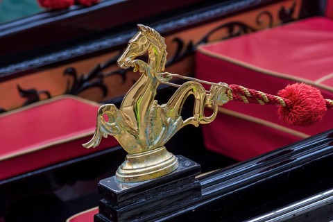 Mythological horse figure made of brass and red pompoms decorate the gondola, Venice, Veneto, Italy