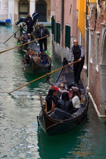 Gondola rides with tourists through the old town canals, Venice, Veneto, Italy