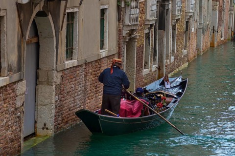 Gondolier with tourists on a canal tour, Venice, Veneto, Italy