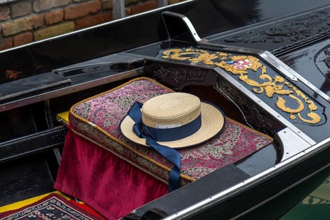 Typical straw hat of a gondolier sitting on a gondola, Venice, Veneto, Italy