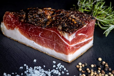 Ham bacon piece on slate plate with salt and peppercorns, delicacy ham fresh from the butcher