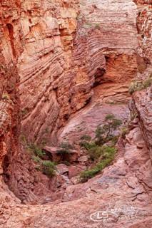 Impressive rock face with visible stratifications and limited vegetation, showing natural erosion,