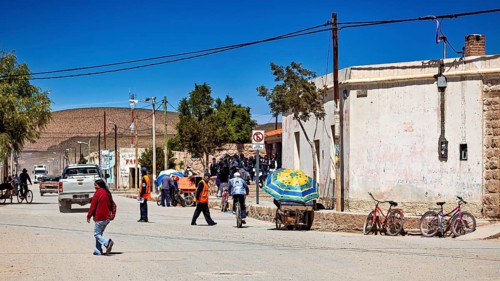 Bustling street scene with people attending a market or meeting in sunny surroundings, San Antonio