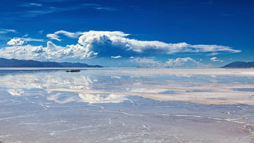 Wide view of a salt lake with cloud reflections in the water, The Salar de Cauchari salt pan near
