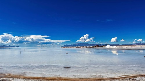 Wide view of a salt lake with blue sky and few clouds, The Salar de Cauchari salt pan near Salta in