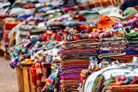 Stacked, colorful blankets and hats at a sales stand, tourist and souvenir market in Santa Rosa de