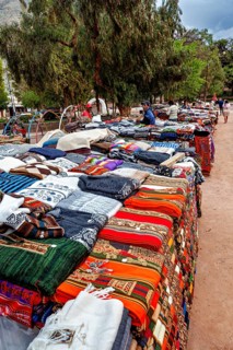 A stand with colorful textiles in a park-like setting, tourist and souvenir market of Santa Rosa de