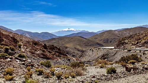 Winding road through a mountainous and dry landscape under blue sky, roads through the Quebrada de
