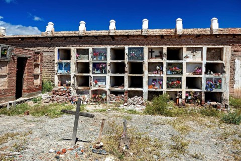 Weathered wall with grave niches and cross in an old cemetery, The cemetery of Cachi in Argentina