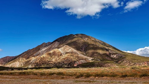 Volcanic landscape under a blue sky with scattered clouds, The landscape of the Quebrada with its