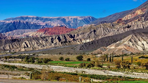 A colourful mountain landscape under a clear blue sky with desert vegetation, The landscape of the