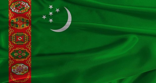 Flag of Turkmenistan with fabric textured background. Close up of National flag of Turkmenistan