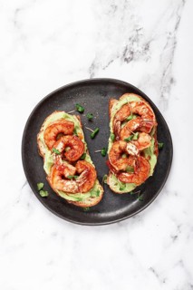Sandwiches with avocado and caramelized shrimp, micro-greens, breakfast, on a plate, top view,