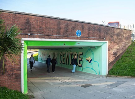 People walking through underpass subway at North Cross roundabout city centre of Plymouth, Devon,