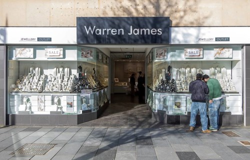 Two men window shopping at Warren James jewellery outlet shop, New George Street, city centre of